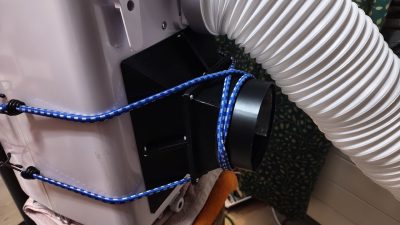 Cowl fitted to the rear of the unit, held on with a blue bungee cord (TRONIC TLK 7000 C2 / Rein / 2026 / 08)